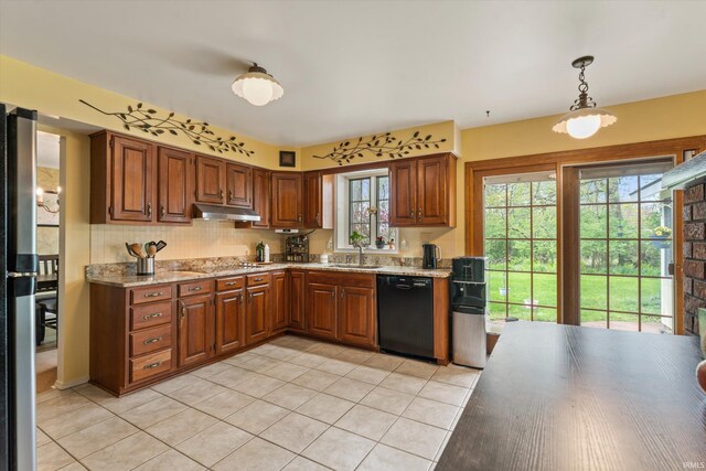 kitchen featuring dishwasher, under cabinet range hood, light tile patterned floors, and plenty of natural light