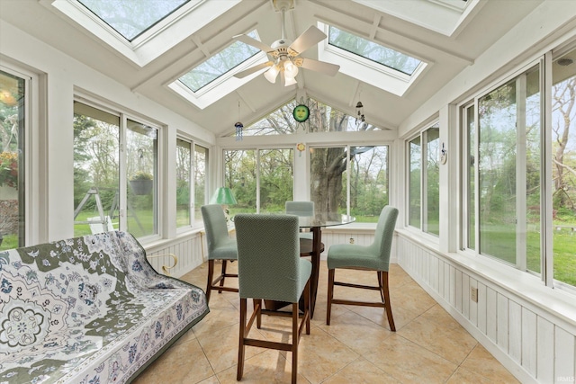 sunroom / solarium featuring a skylight, healthy amount of natural light, and vaulted ceiling