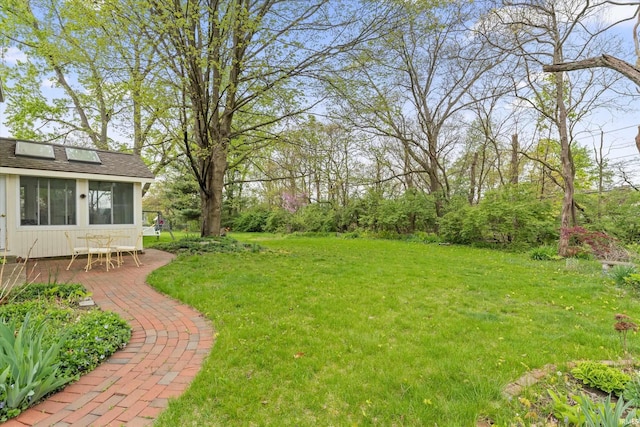 view of green lawn featuring a sunroom