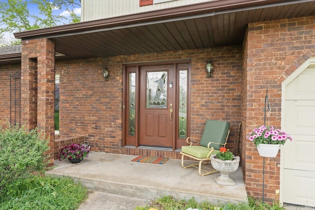 property entrance with brick siding and a porch