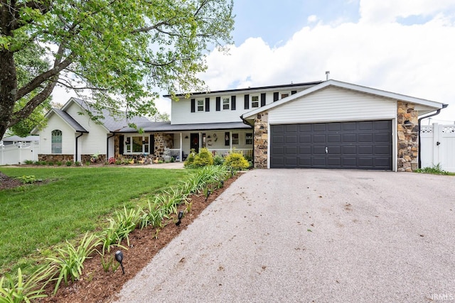 4346 N Centennial Dr, Bloomington, IN 47404 - traditional-style house with asphalt driveway, a porch, stone siding, and an attached garage