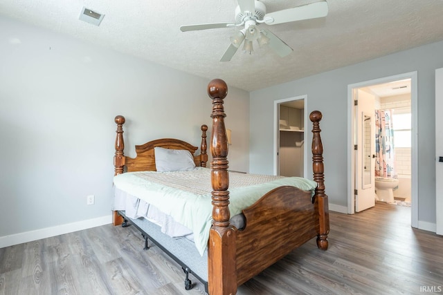 4346 N Centennial Dr, Bloomington, IN 47404 - bedroom featuring wood finished floors, a textured ceiling, baseboards, a ceiling fan, and ensuite bathroom