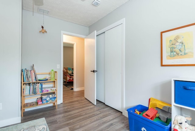 4346 N Centennial Dr, Bloomington, IN 47404 - rec room featuring wood finished floors, a textured ceiling, and attic access
