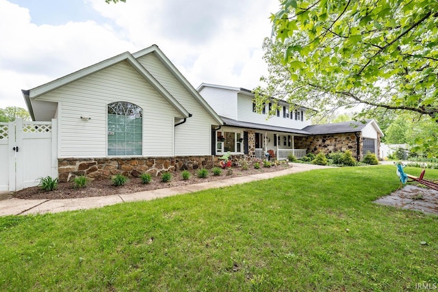 4346 N Centennial Dr, Bloomington, IN 47404 - traditional-style home with stone siding, covered porch, an attached garage, and a gate