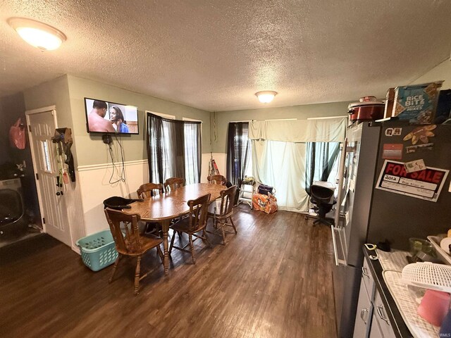 dining space with a textured ceiling and dark wood finished floors