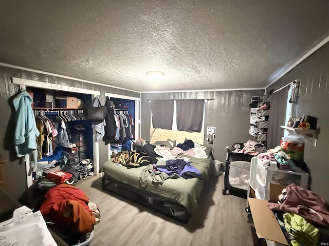 bedroom featuring wood finished floors and a textured ceiling