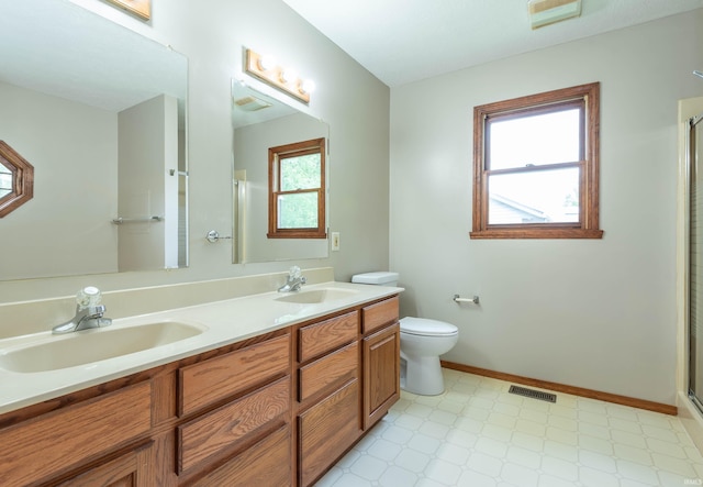 bathroom with tile patterned floors, a shower with shower door, toilet, and double vanity