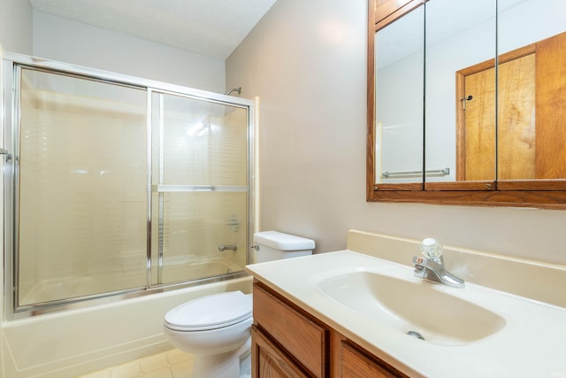 full bathroom featuring toilet, combined bath / shower with glass door, and vanity