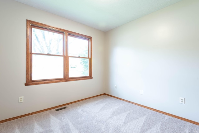 carpeted empty room featuring baseboards
