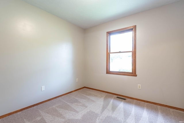 carpeted spare room featuring baseboards
