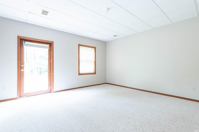 spare room featuring carpet, baseboards, and a paneled ceiling