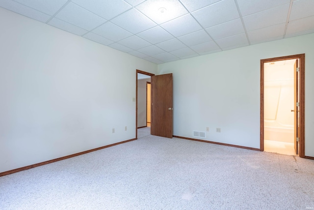 carpeted empty room featuring baseboards and a paneled ceiling