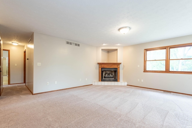 unfurnished living room with light carpet, a fireplace, and baseboards