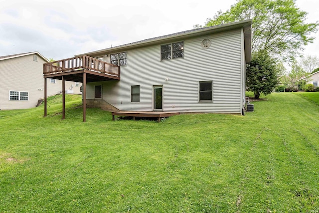 rear view of property featuring a deck and a lawn