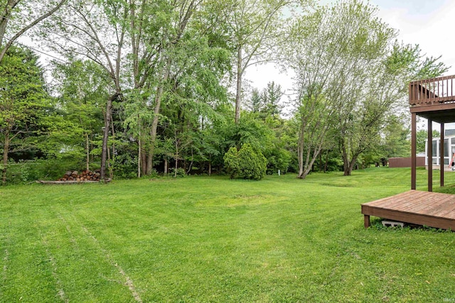 view of grassy yard featuring a deck