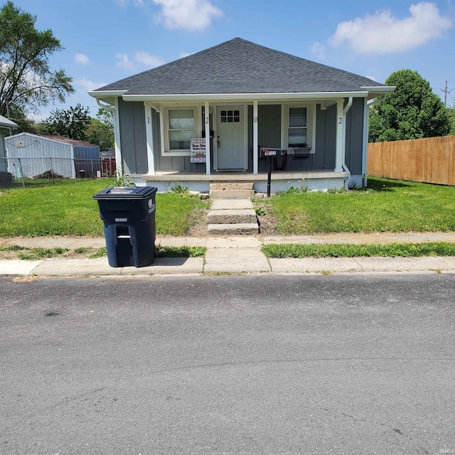1202 Magnolia Ave, Frankfort, IN 46401 - bungalow-style house featuring a porch, fence, and a shingled roof