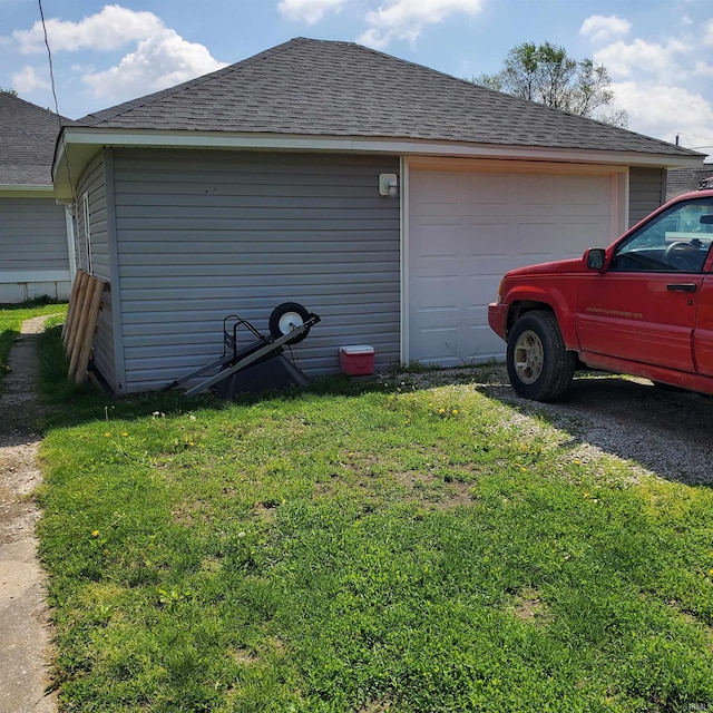1202 Magnolia Ave, Frankfort, IN 46401 - view of side of property featuring a garage, a shingled roof, and a yard