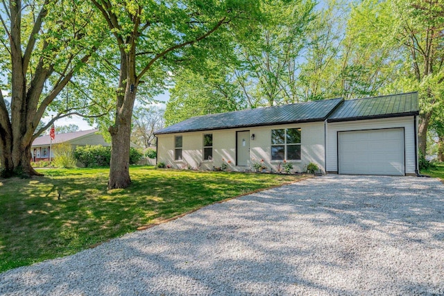 ranch-style house with a garage, gravel driveway, a front lawn, and metal roof