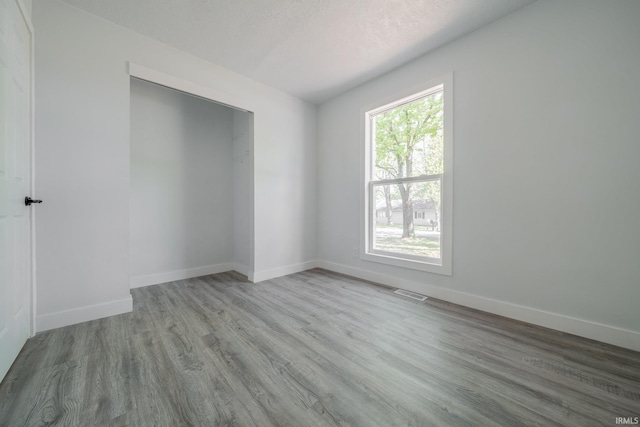 unfurnished room with wood finished floors and baseboards