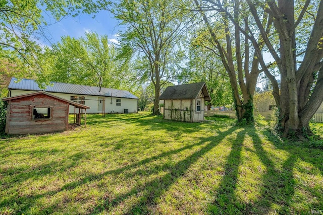view of grassy yard with a storage unit and an outbuilding