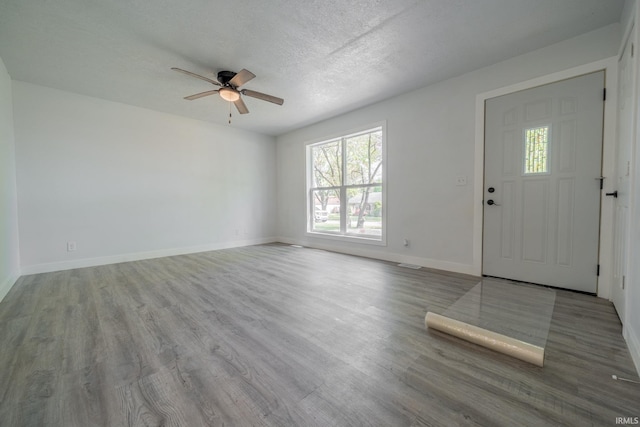 foyer with ceiling fan, wood finished floors, baseboards, and a textured ceiling