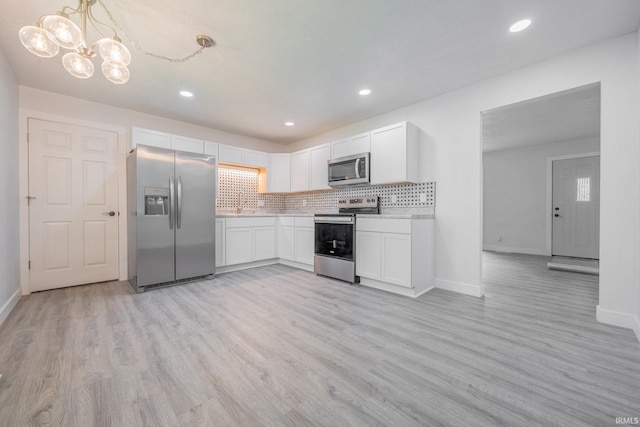 kitchen featuring stainless steel appliances, baseboards, light countertops, and recessed lighting