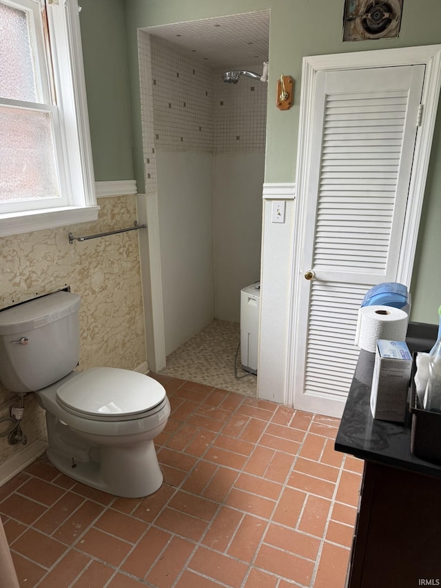 full bath with wainscoting, a shower, brick patterned flooring, and toilet