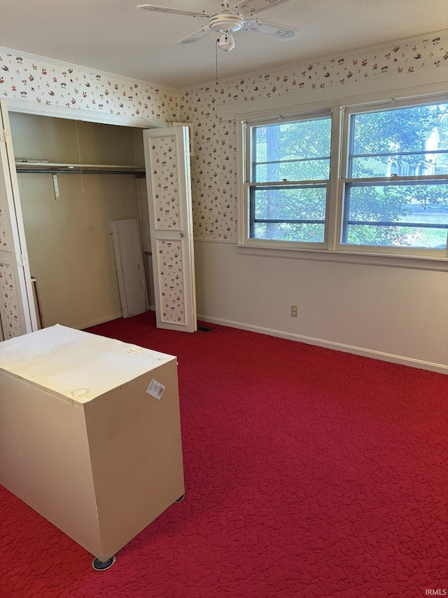 unfurnished bedroom featuring baseboards, carpet flooring, a closet, and ceiling fan