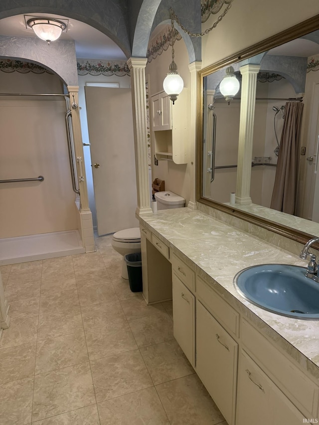 bathroom with decorative columns, curtained shower, vanity, toilet, and tile patterned flooring