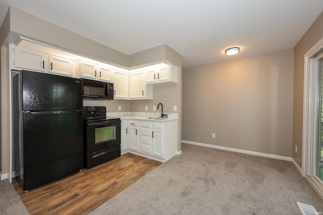 7001 Sweet Gum Ct, Fort Wayne, IN 46804 - kitchen featuring black appliances, a sink, white cabinetry, light countertops, and dark carpet