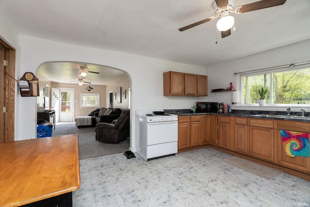 kitchen featuring white electric range, a sink, arched walkways, a ceiling fan, and black microwave