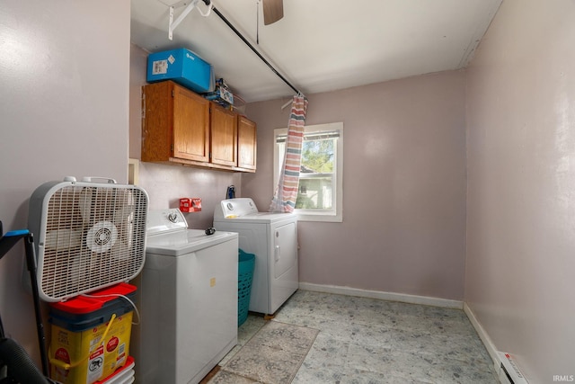 clothes washing area with washing machine and dryer, cabinet space, baseboards, and a baseboard radiator