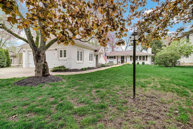 ranch-style house with a garage, concrete driveway, and a front lawn