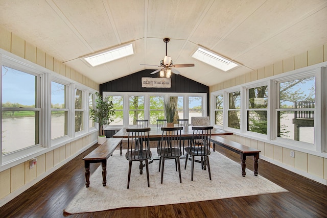 sunroom with a skylight, wood finished floors, vaulted ceiling, plenty of natural light, and wood walls
