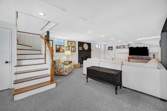 carpeted living area featuring a textured ceiling, stairs, and recessed lighting