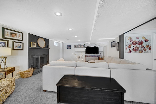 carpeted living area featuring a textured ceiling, a brick fireplace, and recessed lighting