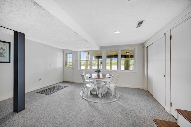 dining space featuring healthy amount of natural light, a textured ceiling, carpet flooring, and baseboards