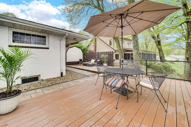 wooden terrace with outdoor dining space, outdoor lounge area, and fence