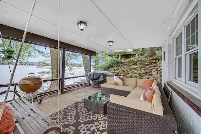 sunroom / solarium featuring a water view and an outdoor living space