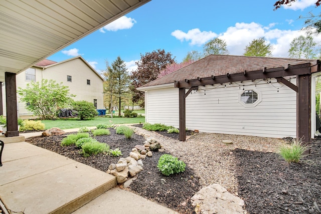 view of home's exterior with roof with shingles, a patio, and a yard