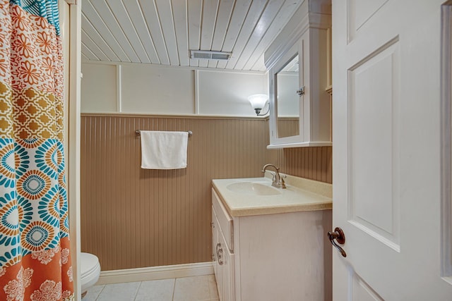 bathroom with toilet, tile patterned flooring, vanity, baseboards, and a shower with curtain