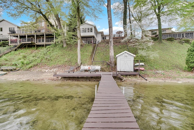dock area featuring stairway and a deck with water view
