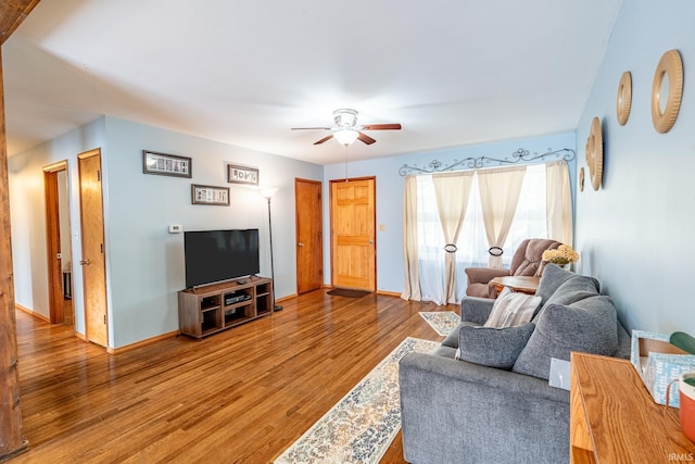 living area featuring a ceiling fan, wood finished floors, and baseboards