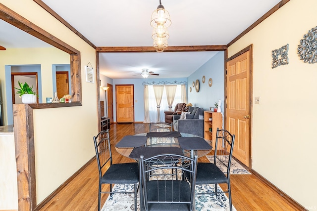 dining room featuring wood finished floors, ceiling fan, beam ceiling, and baseboards