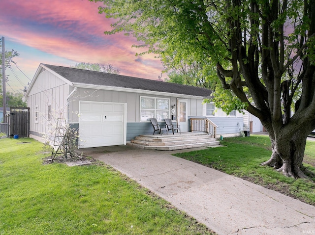 single story home with an attached garage, concrete driveway, a yard, and board and batten siding