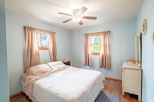 bedroom featuring wood finished floors, baseboards, and a ceiling fan