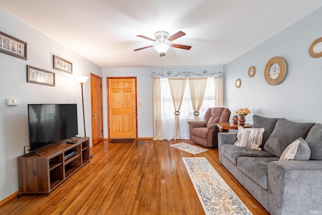 living area with a ceiling fan and wood-type flooring