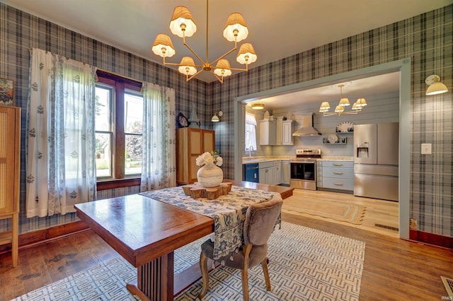 489 S Lincoln St, Orleans, IN 47452 - dining area featuring wallpapered walls, a chandelier, light wood-style floors, and baseboards