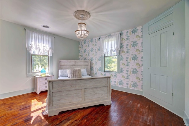 489 S Lincoln St, Orleans, IN 47452 - bedroom with wallpapered walls, dark wood-type flooring, baseboards, and a chandelier