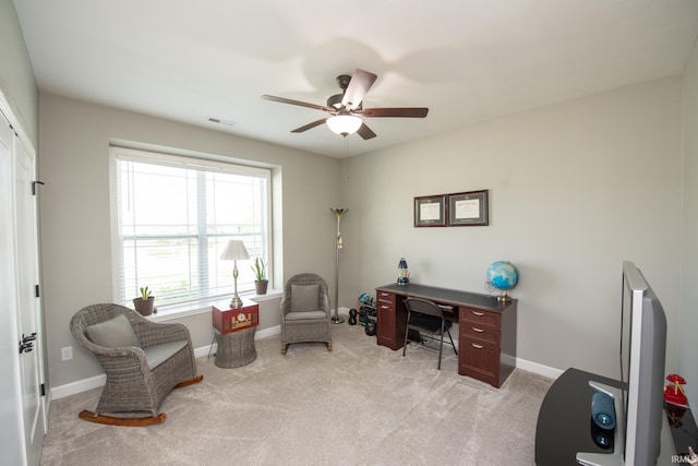 office space with a ceiling fan, light colored carpet, and baseboards